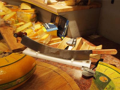Spezielles Messer, Käsemesser, Käse schneiden, dicke oder dünne Scheiben abtrennen, gebogene Form, harte und scharfe Klinge.